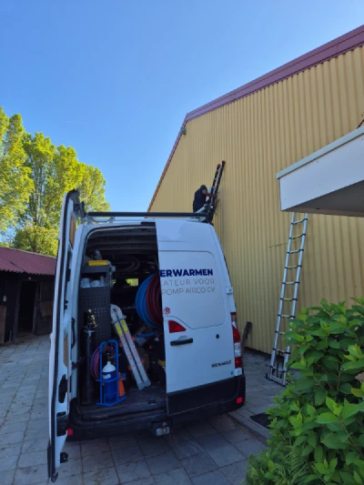 Monteur van Slim Verwarmen op ladder van managehal voor plaatsen airco