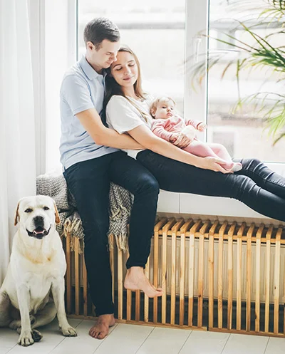 Familie zit op radiator die door CV-ketel is verwarmd