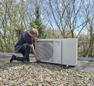 Monteur plaatst warmtepomp op het dak