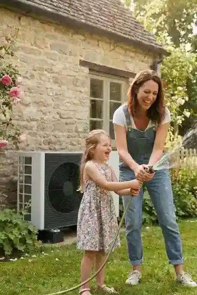 Moeder en dochter spelen in de tuin met warmtepomp op achtergrond