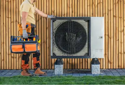 Monteur installeert gesubsidieerde warmtepomp