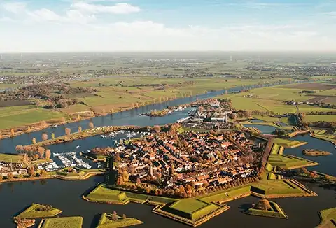 Luchtopname van dorp met middeleeuwse vesting en grachten